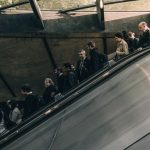 周りを気にして整列しエスカレーターをおりる人達